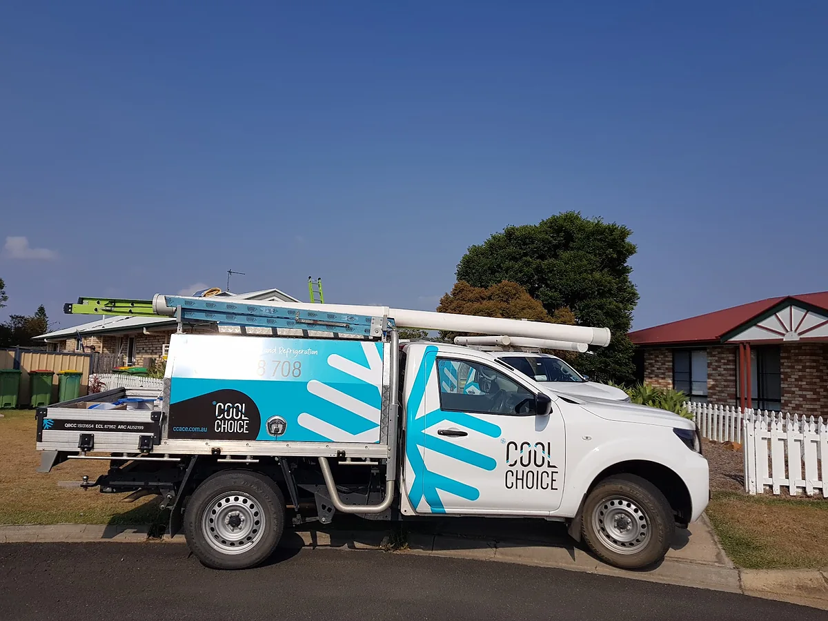 A white Cool Choice ute with cyan livery and ladders parked in a suburban street